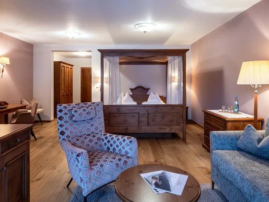 Das 4-Sterne-Hotel am Achensee: der Wiesenhof Gemütliches Hotelzimmer mit Himmelbett, Sesseln und Holzmöbeln