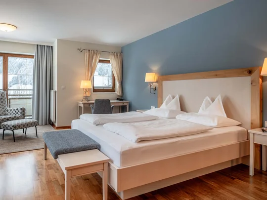 Wiesenhof am Achensee | Das Hotel in Pertisau Gemütliches Hotelzimmer mit Doppelbett, Sesseln und Fenster mit Blick auf verschneite Berge