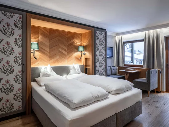 Wiesenhof am Achensee | Das Hotel in Pertisau Gemütliches Hotelzimmer mit Doppelbett, Sitzecke und Balkon mit Bergblick