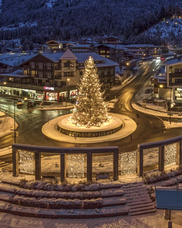 Wiesenhof am Achensee | Das Hotel in Pertisau Weihnachtsbaum beleuchtet auf einem Kreisverkehr in einem verschneiten Dorf bei Nacht