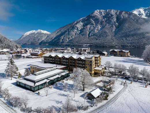 Wiesenhof am Achensee | Das Hotel in Pertisau Winterliche Alpenlandschaft mit schneebedecktem Dorf und See unter klarem blauem Himmel