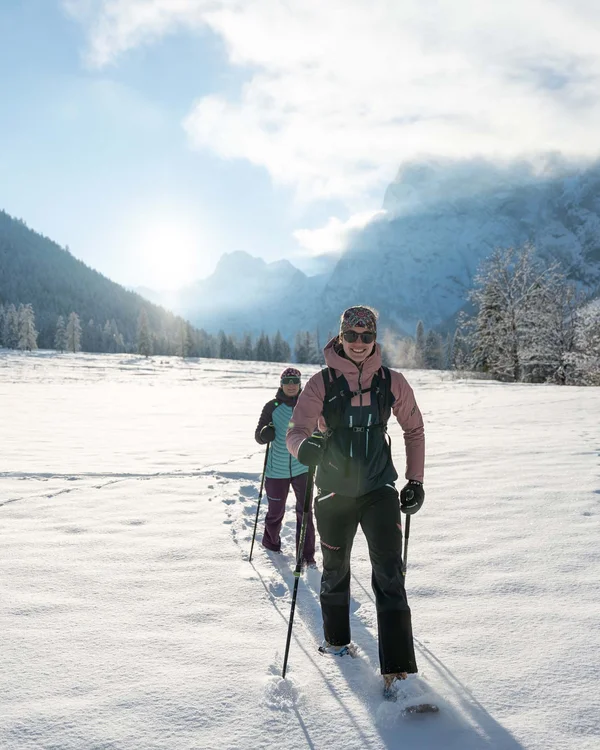 Wiesenhof am Achensee | Das Hotel in Pertisau Zwei Frauen wandern mit Schneeschuhen im sonnigen schneebedeckten Tal