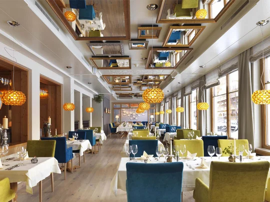 Wiesenhof am Achensee | Das Hotel in Pertisau Helles Restaurant mit grünen und blauen Stühlen und Pendelleuchten