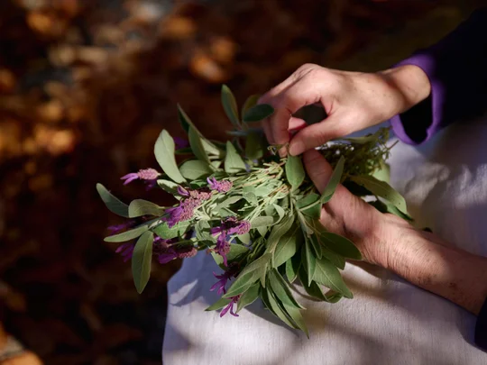 Wiesenhof in Pertisau: the Entner family and team Hands holding a bouquet of green leaves and purple flowers