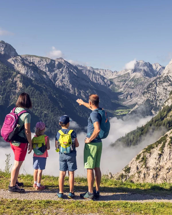 Wiesenhof am Achensee | Das Hotel in Pertisau Familie mit Rucksäcken genießt Bergblick bei Wanderung in den Alpen
