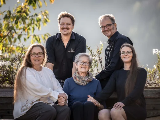 Wiesenhof in Pertisau: the Entner family and team Five family members smiling outdoors holding hands on a sunny day