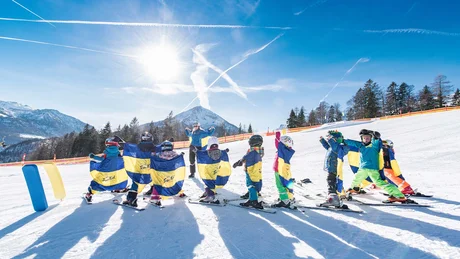 Wiesenhof from all perspectives Children in ski class with instructor on sunny slope in front of mountain scenery