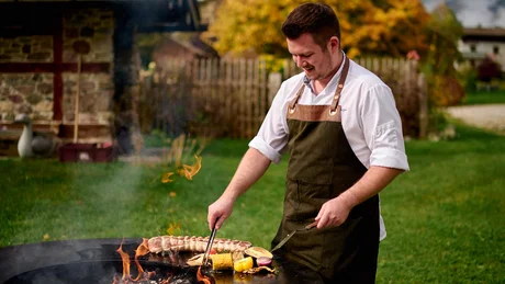 Wiesenhof from all perspectives Man grilling sausages and vegetables outdoors on an autumn day