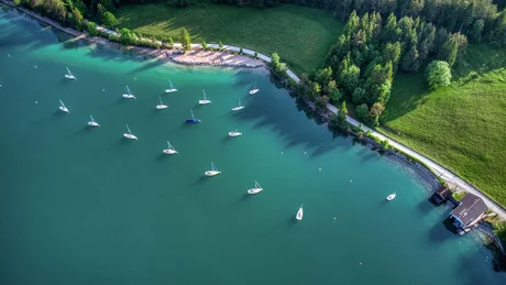 Wiesenhof from all perspectives Aerial view of sailboats on blue lake by green shore with forest