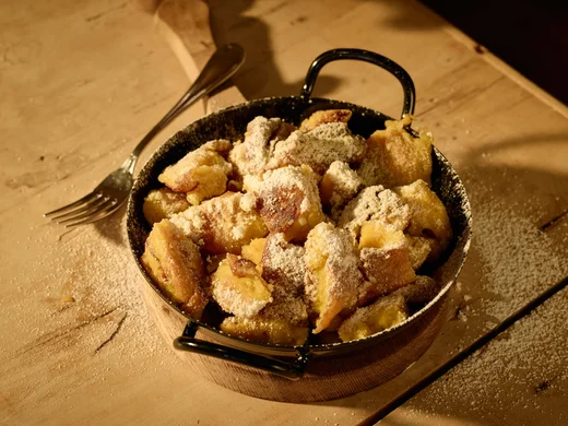 Cuisine at Wiesenhof: restaurant in Pertisau Kaiserschmarrn in a pan sprinkled with powdered sugar on wooden surface