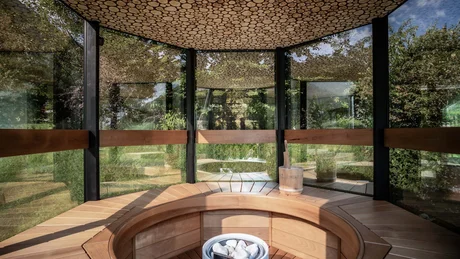Wiesenhof from all perspectives Modern wooden sauna interior with glass walls and log-patterned wooden ceiling