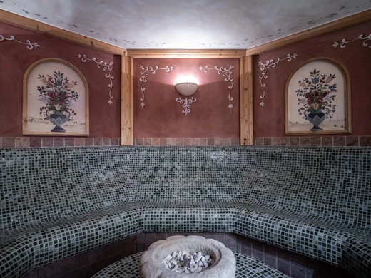 Wiesenhof – your spa hotel in Tyrol Tiled seating area with floral wall paintings and wall light