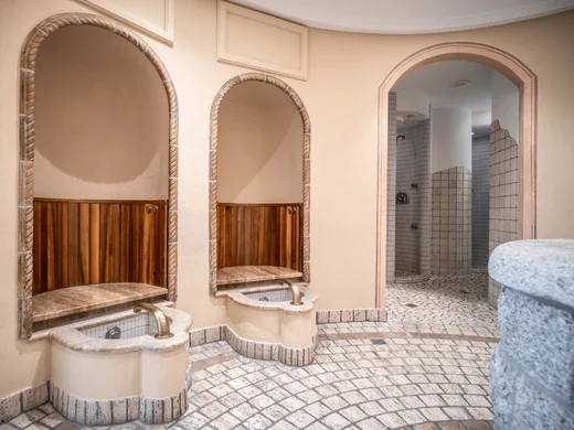 Wiesenhof – your spa hotel in Tyrol Modern spa area with mirrors, water taps, and tiled shower stalls