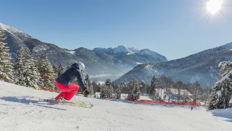 Wiesenhof from all perspectives Skier in red pants skiing down snowy mountain on sunny day with mountains in background