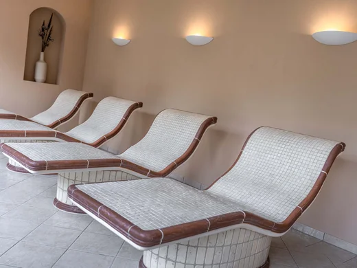 Wiesenhof – your spa hotel in Tyrol Several ergonomic ceramic loungers against a wall with wall lights and vase