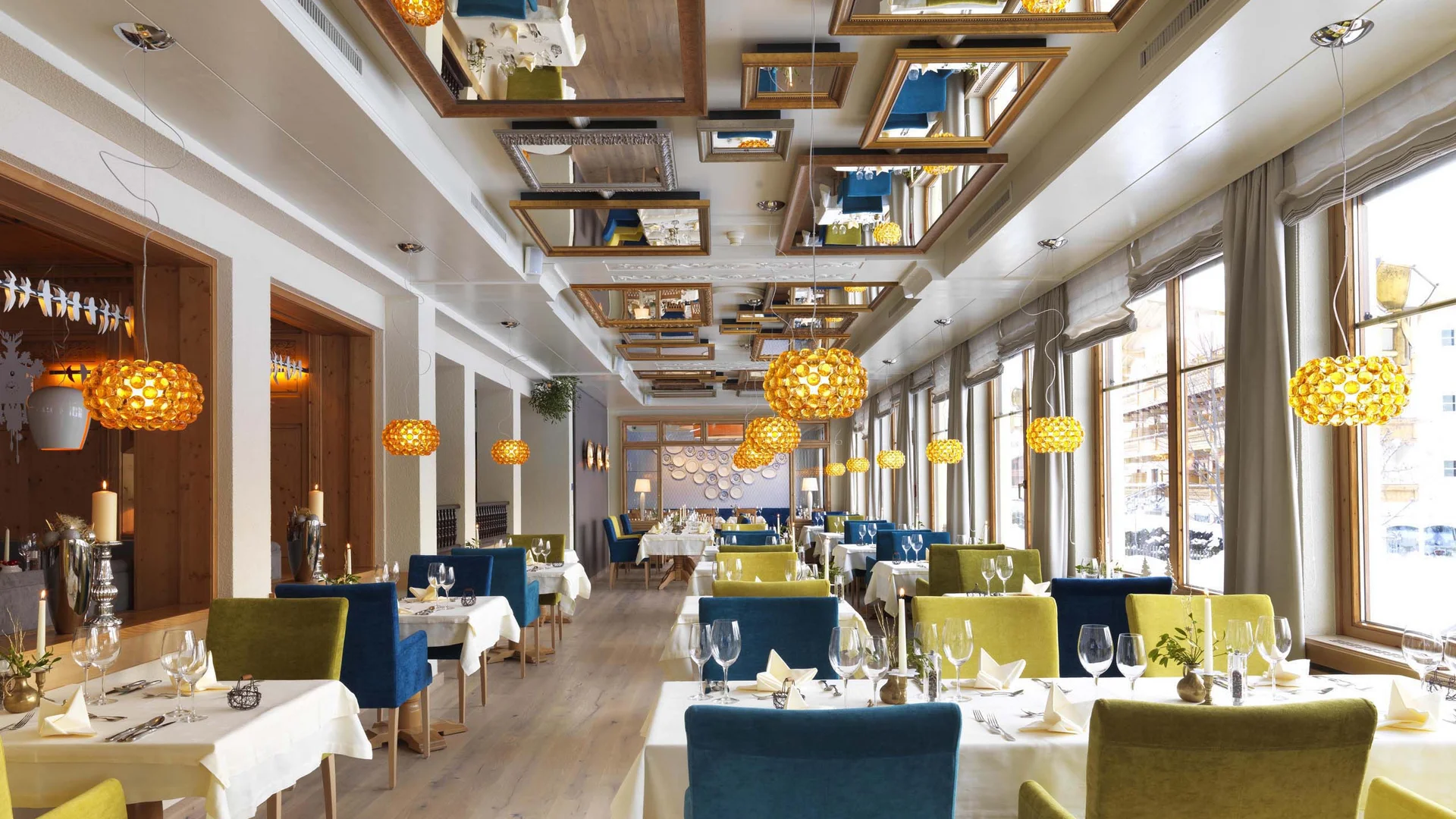 Cuisine at Wiesenhof: restaurant in Pertisau Bright restaurant interior with green and blue chairs and pendant lights